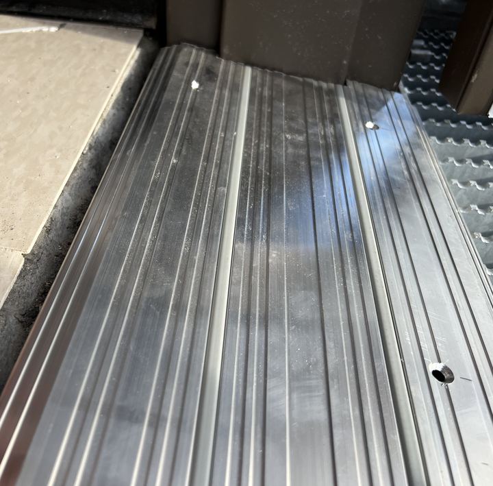 Seuil d'aluminium posé sous une porte commerciale